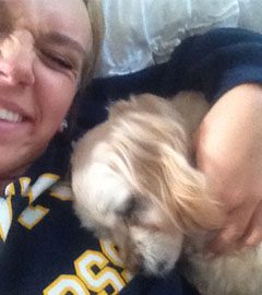 A woman and her dog laying on the ground.