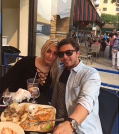 A man and woman sitting at an outdoor table.