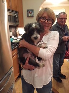 A woman holding a dog in her arms.