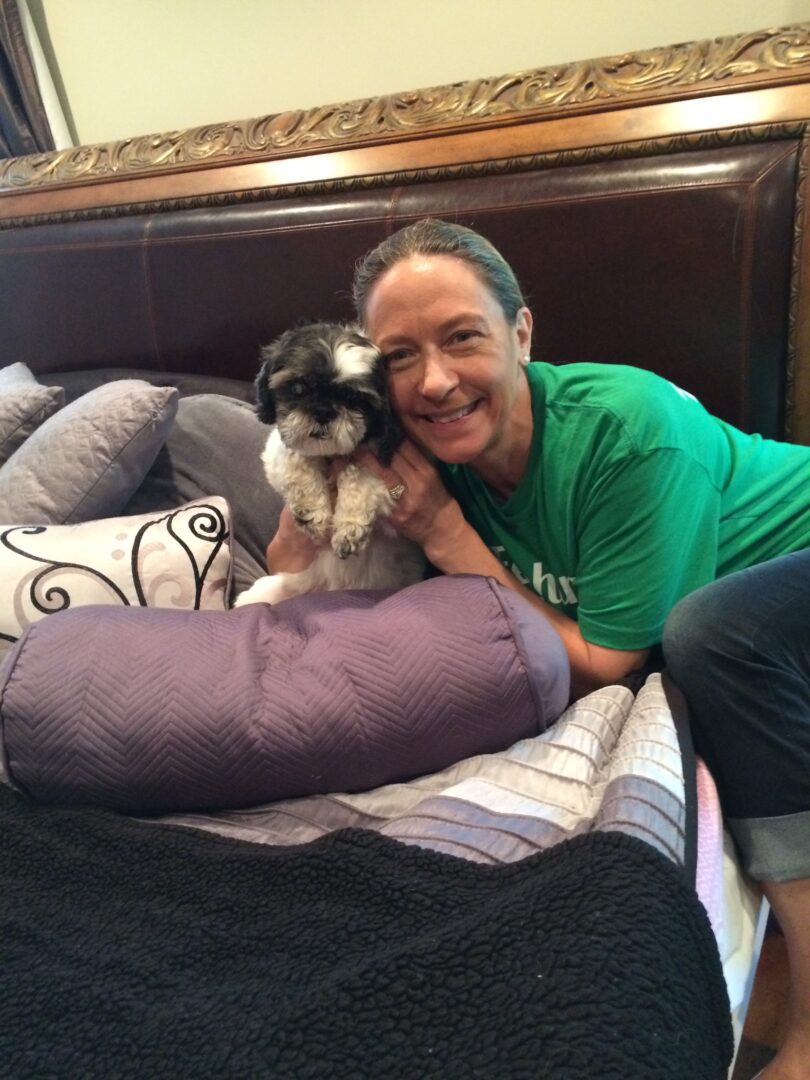 A man and his dog laying on the bed