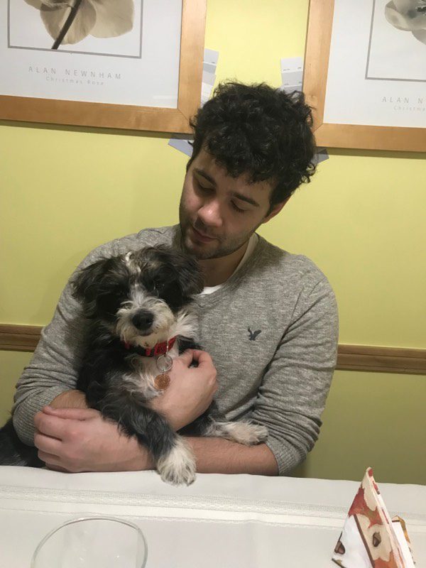 A man holding a dog in his arms.