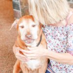 A woman holding a dog in her arms.