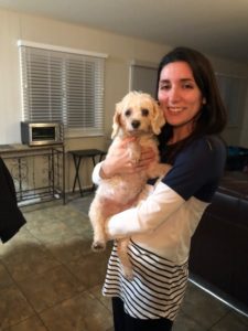 A woman holding her dog in her arms.