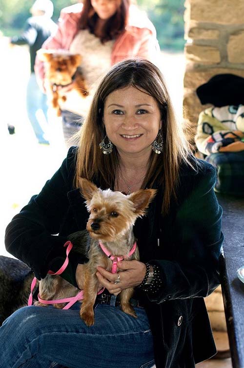 A woman holding her dog in her arms.