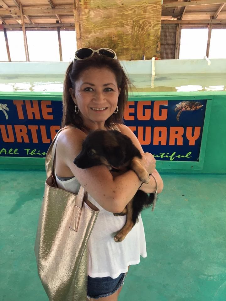 A woman holding a black cat in her arms.